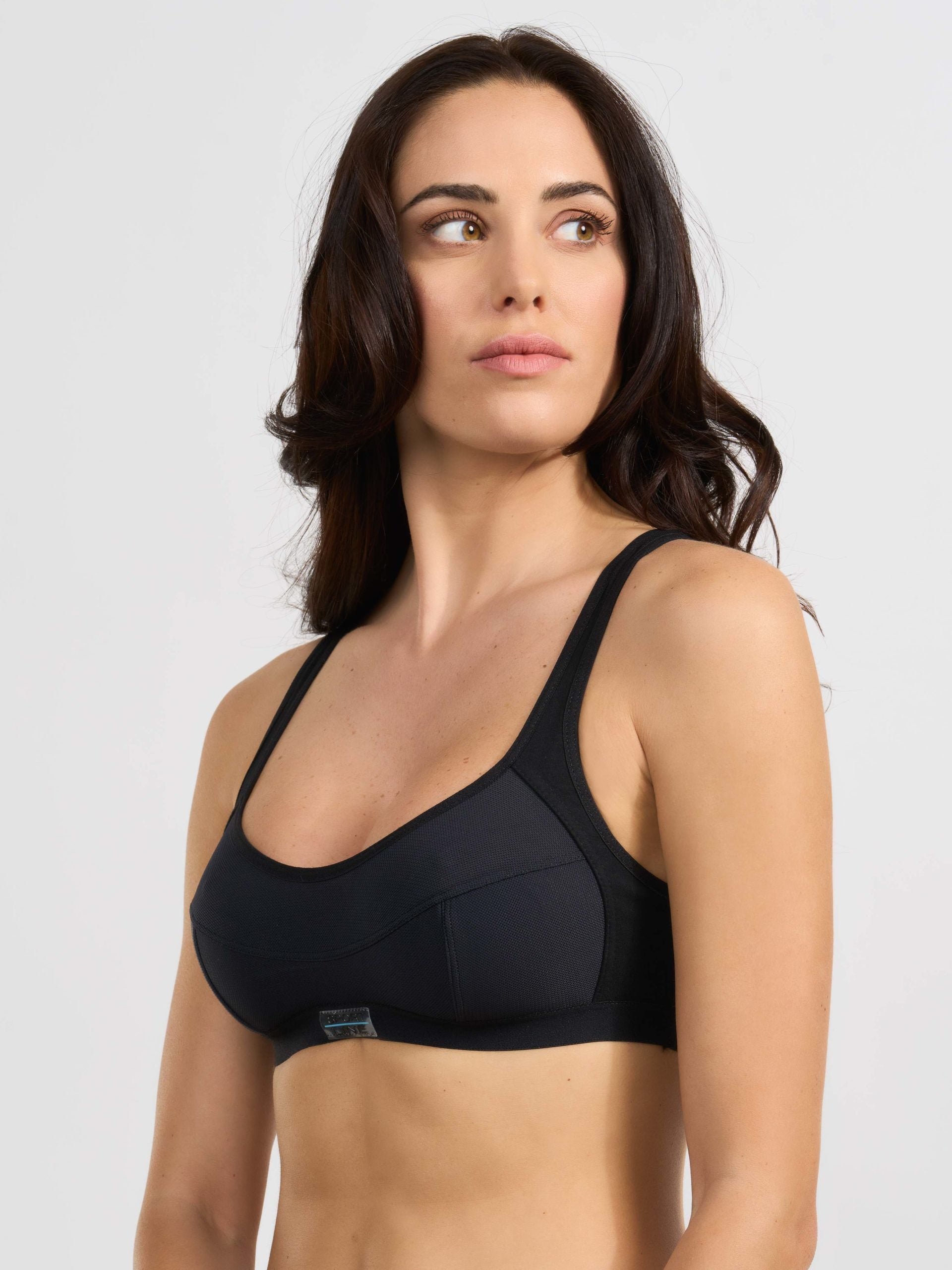 Reggiseno sportivo nero a bustino con taglio sagomato e spalline larghe.